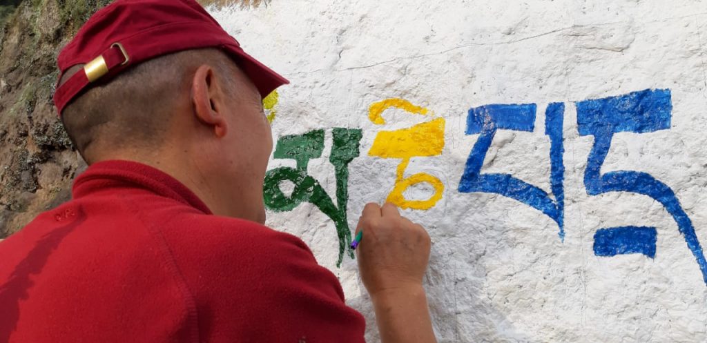 Pintando tiburones para un thangka en una pared blanca.