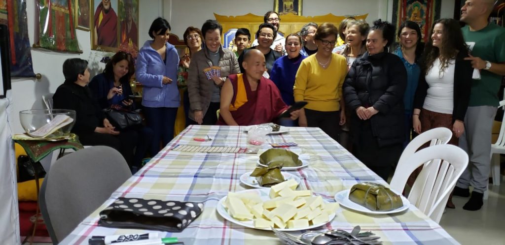 Grupo de personas reunidas alrededor de una mesa con alimentos.