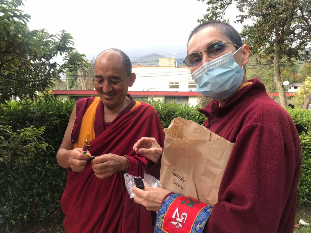 Dos monjes budistas leyendo un libro al aire libre.