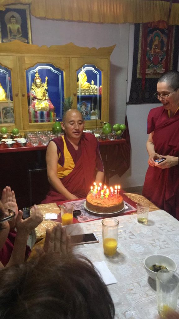 Sala del Centro con velas encendidas y varias personas reunidas alrededor de una mesa.