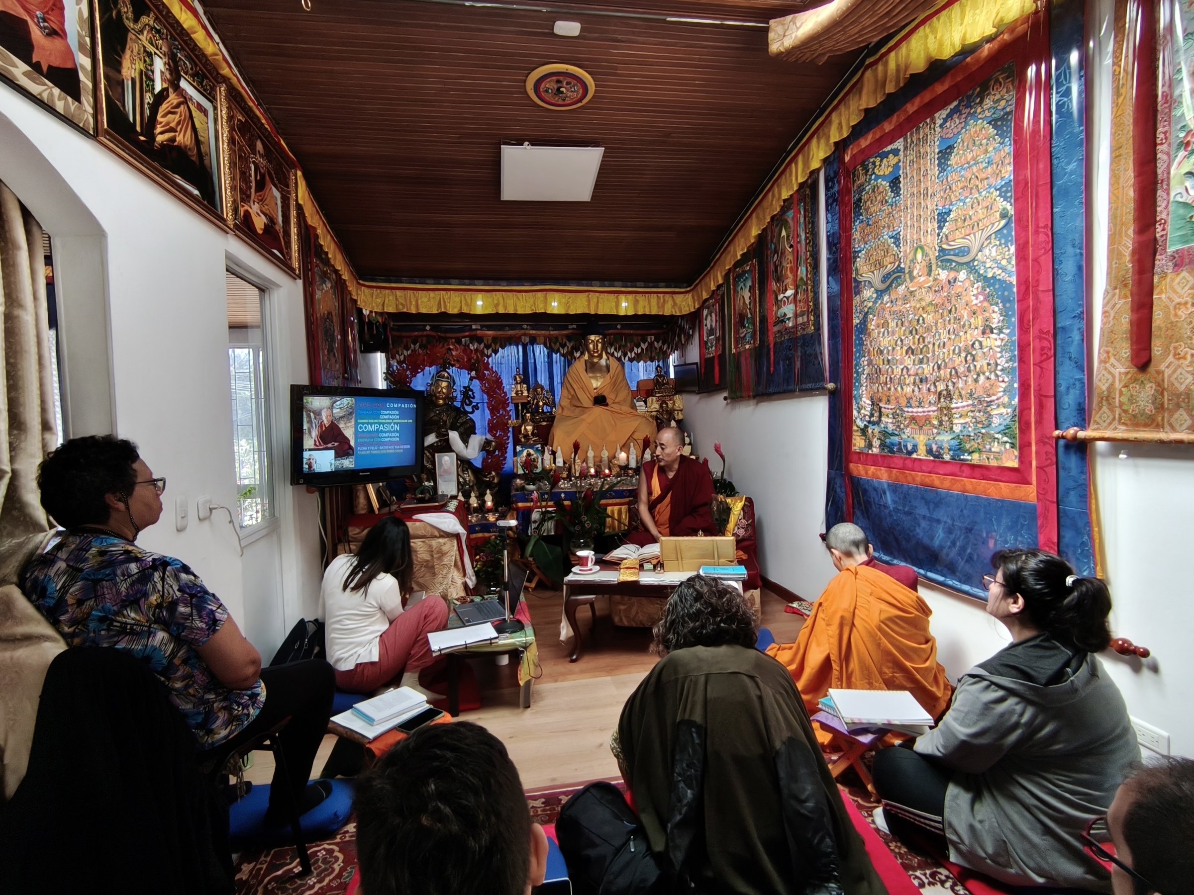 Un grupo de practicantes escucha al maestro durante una enseñanza en la gompa del Centro Yamantaka.